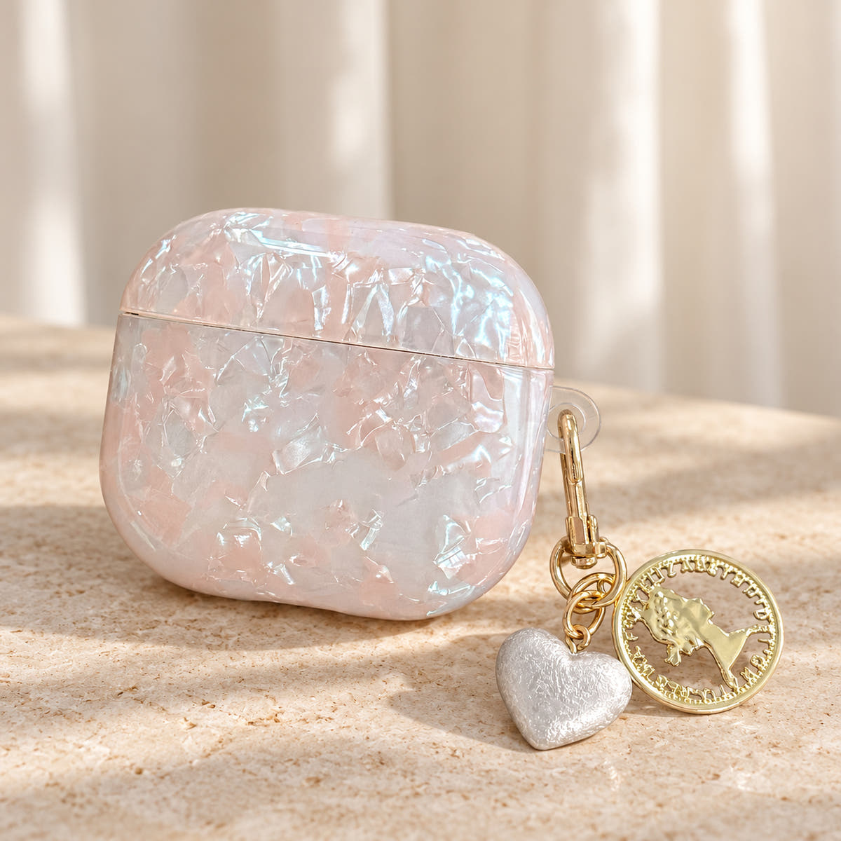 Opal Marble AirPods Case in Opal, portrait setting with original attached charms on a warm cream background
