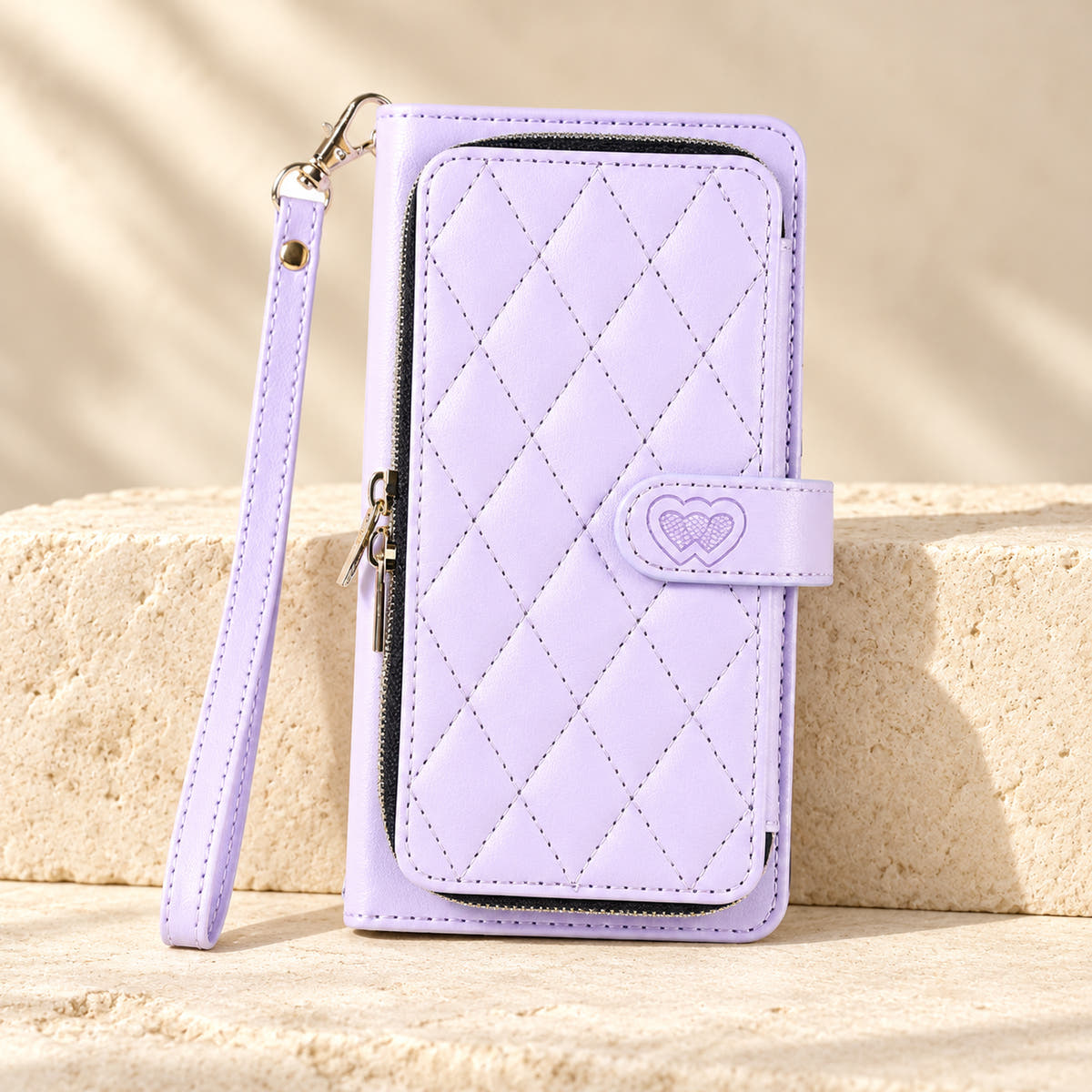 Lavender padded zip iPhone wallet case with matching wrist strap on limestone