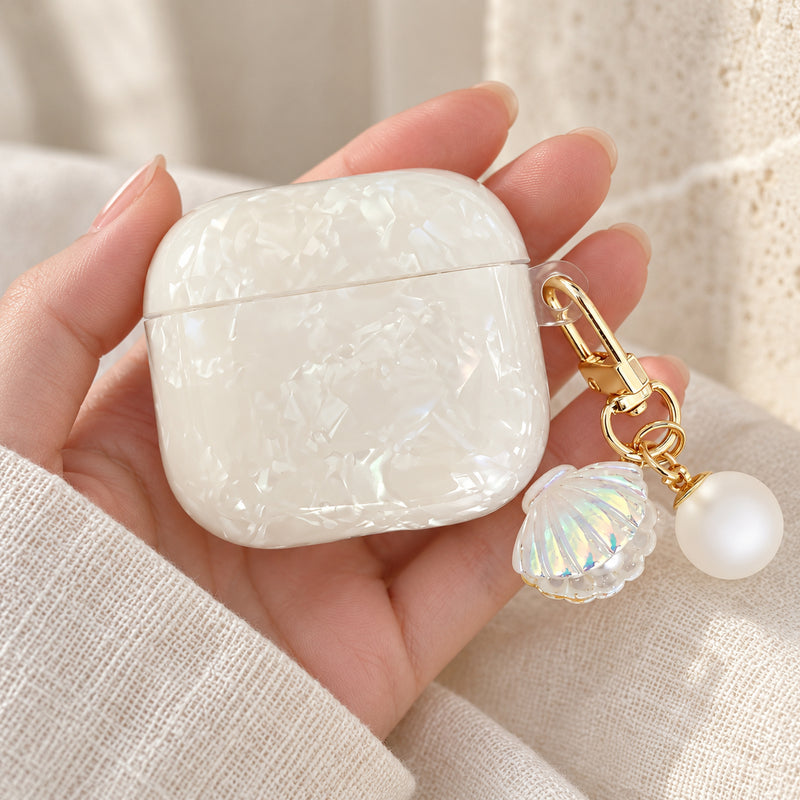 Pearl Marble AirPods case in Apricot — handheld front view with matching shell-shaped charm