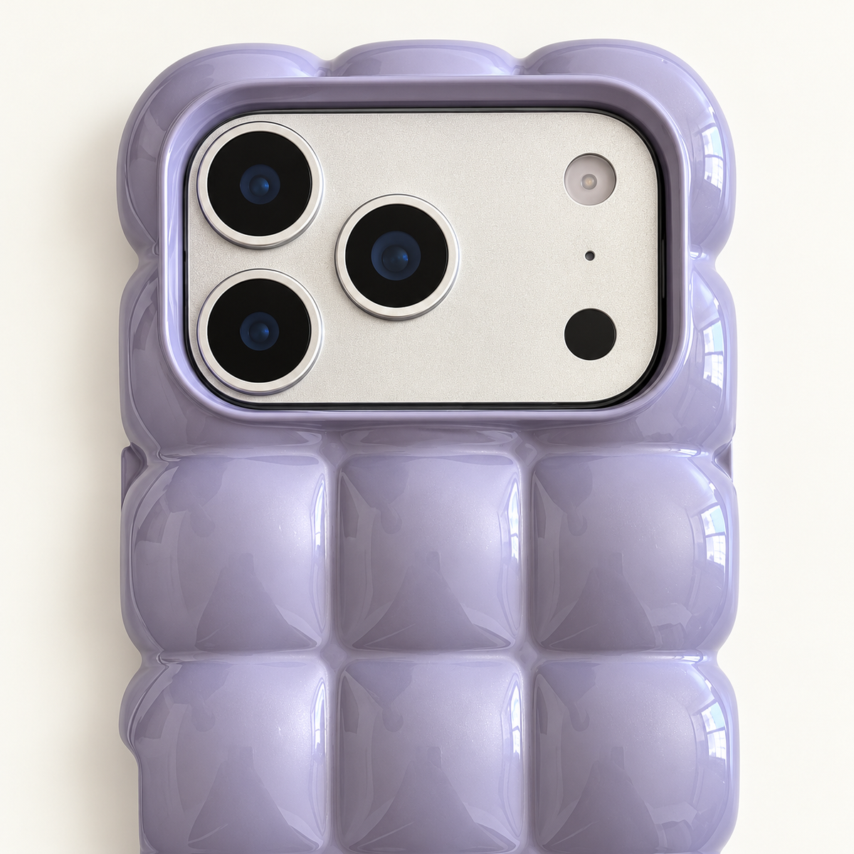 Lavender puffy grid iPhone case with rounded-square back and scalloped edges — close-up of camera surround and sculpted grid.