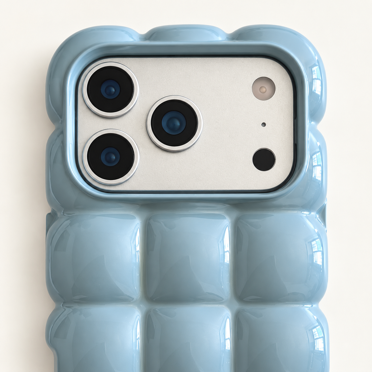 Sky Blue puffy grid iPhone case with rounded-square back and scalloped edges — close-up of camera surround and sculpted grid.