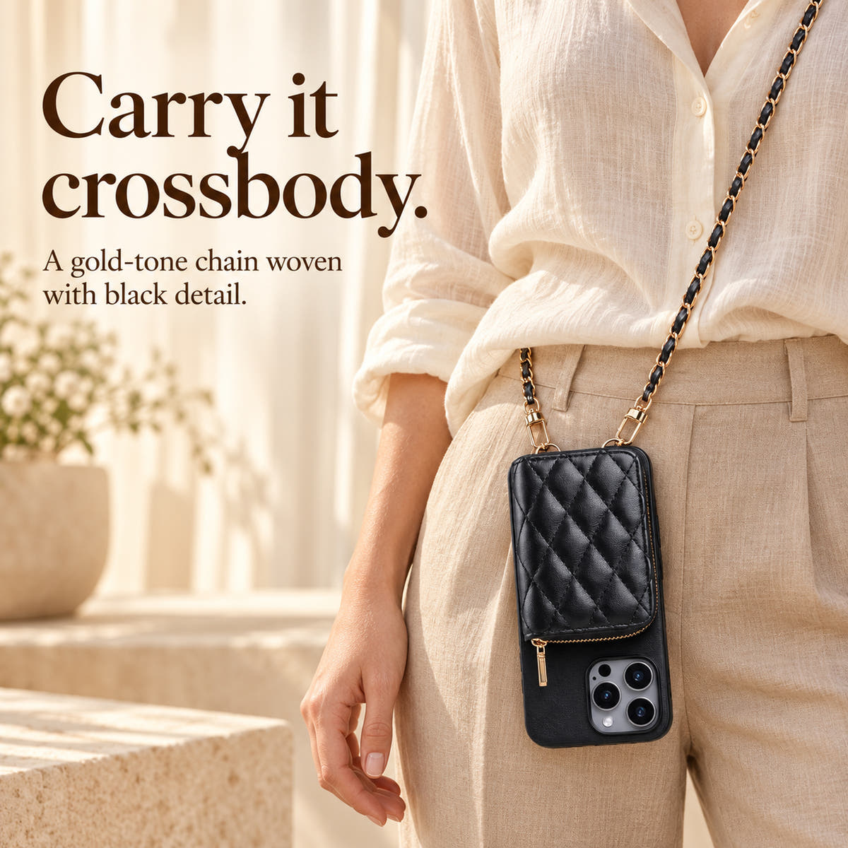 Black quilted iPhone wallet case worn crossbody on its gold-and-black woven chain with the camera below the wallet