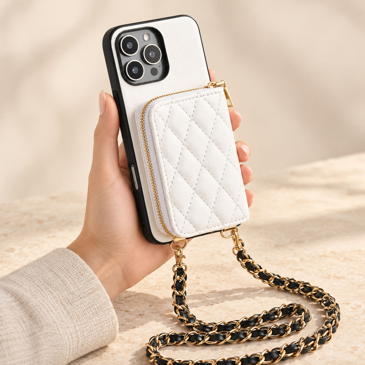 White quilted iPhone wallet case — handheld view with zip wallet and chain