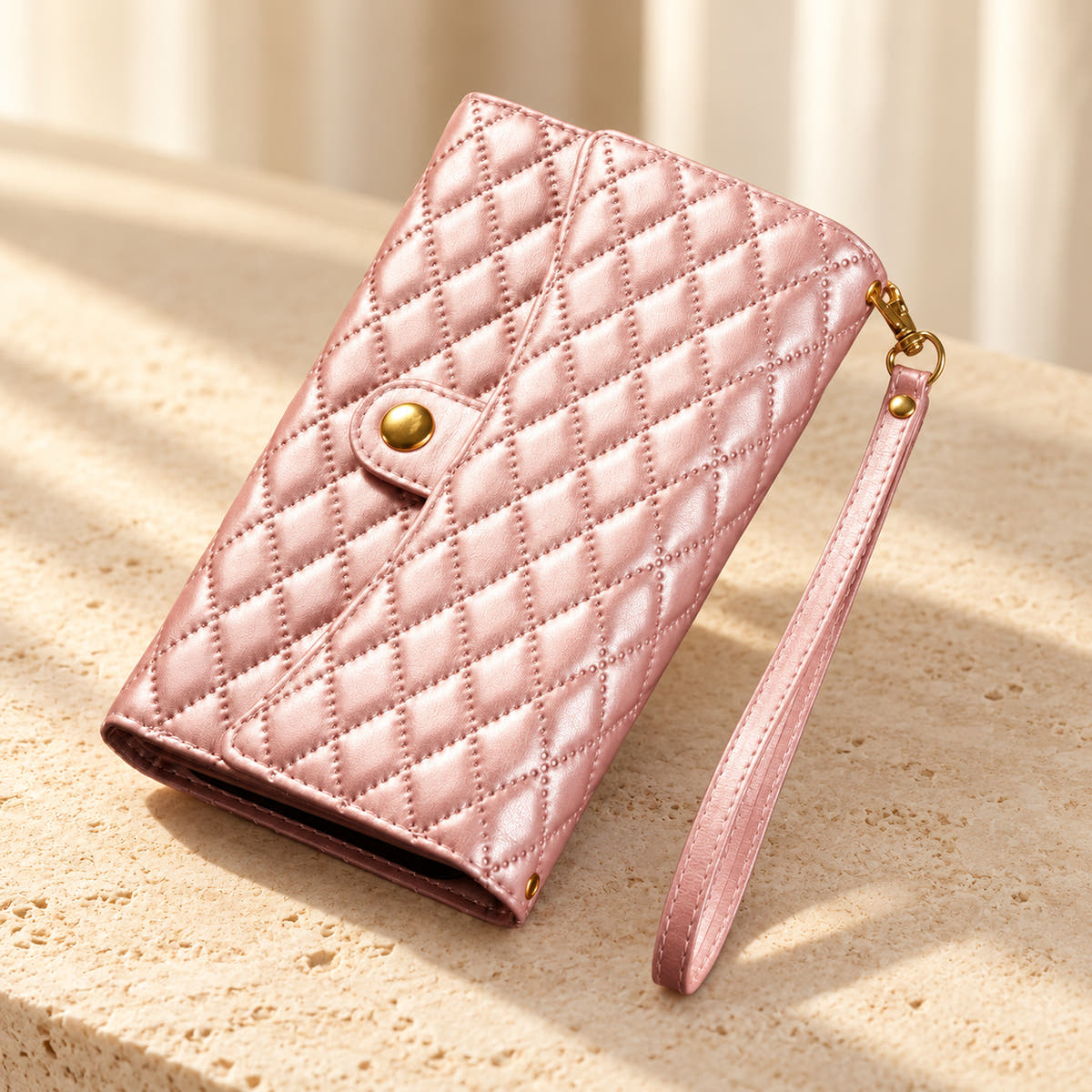 Quilted Zip Wallet iPhone case in Pink on cream limestone, with the closed diamond-quilted front, snap flap and matching wrist loop.