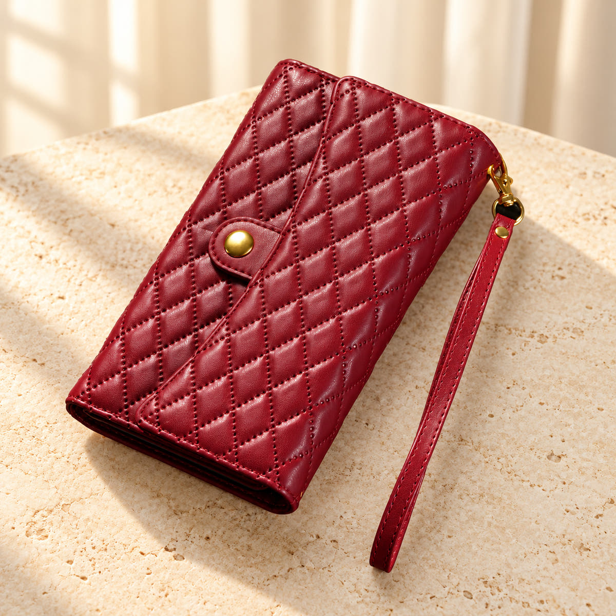 Quilted Zip Wallet iPhone case in Red on cream limestone, with the closed diamond-quilted front, snap flap and matching wrist loop.