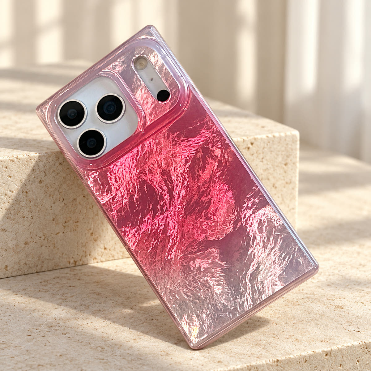 Radiant Wave iPhone case resting diagonally on cream limestone with the reflective back visible