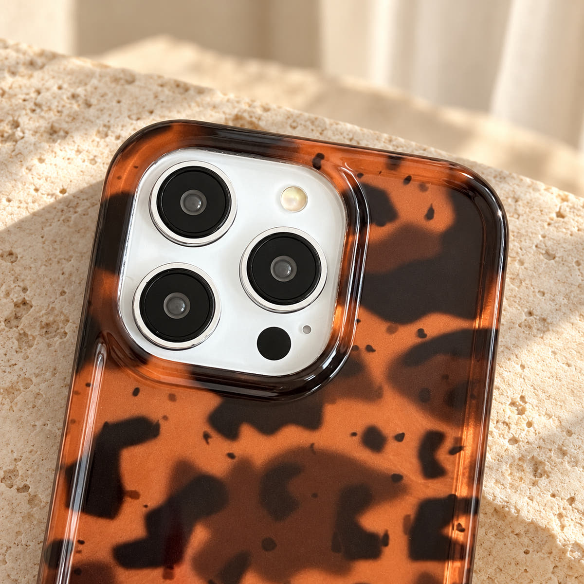 Close-up of the Sienna Luxe Brown case camera opening, clear camera rim and surrounding tortoiseshell print.