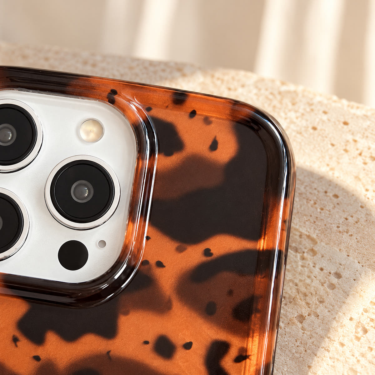 Detail of the Sienna Luxe Brown top corner showing the amber-brown artwork and transparent rounded rim.