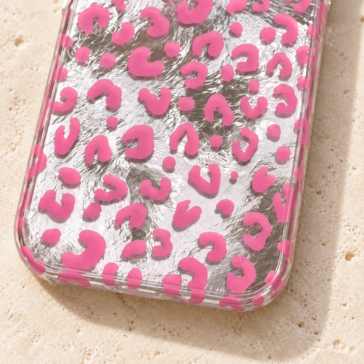 Pink leopard print and crinkled silver finish in close-up, with the clear curved bottom edge visible.