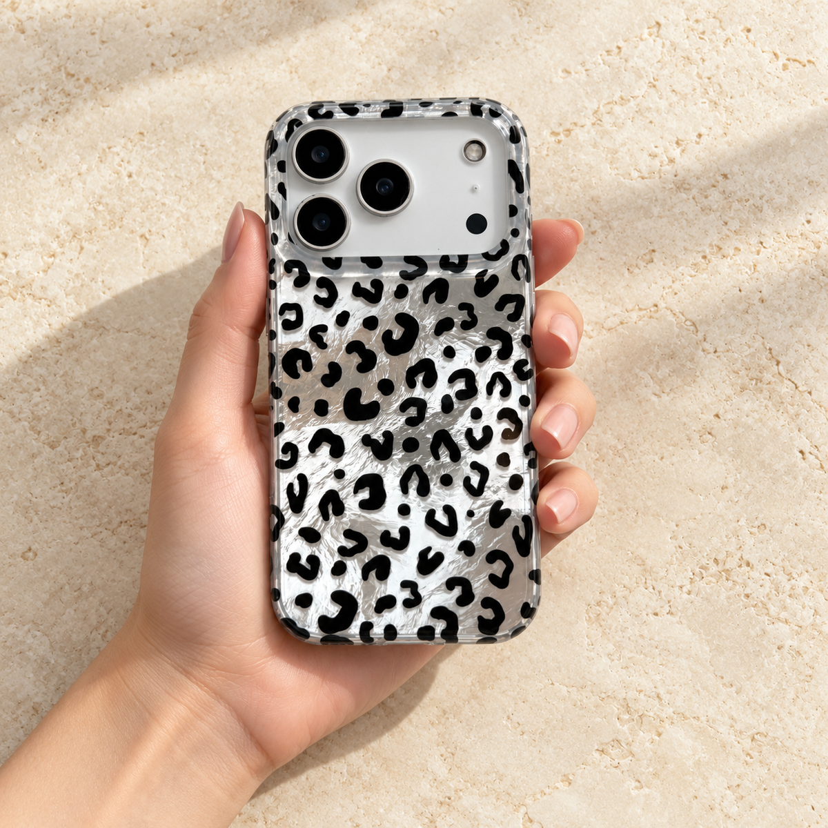 Black leopard iPhone case resting flat in one hand, viewed from above.