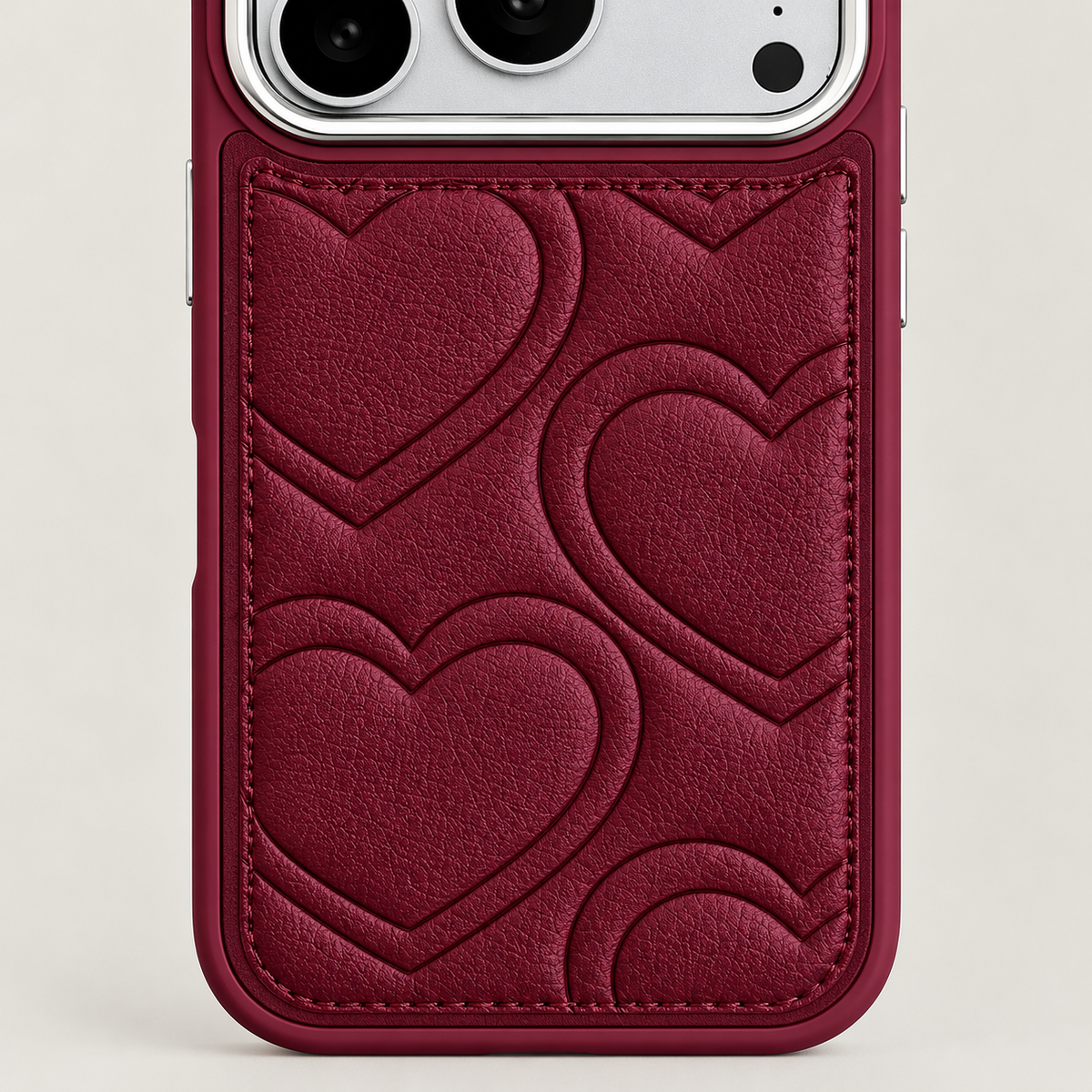 Textured heart iPhone case in Burgundy — heart pattern and stitched border close-up.