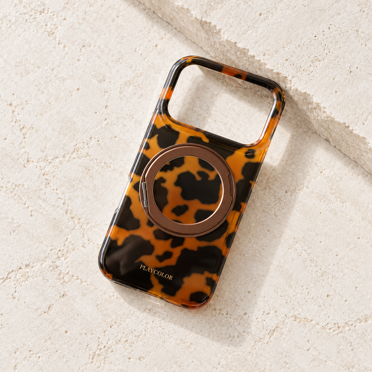 Amber tortoiseshell ring stand case shown without a phone, with its camera opening visible.