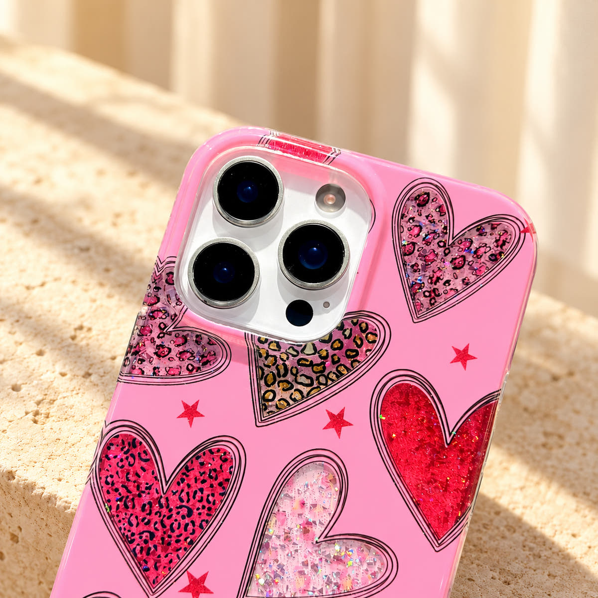Close-up of the Valentina Sparkle Heart Pink iPhone case camera opening and surrounding glitter heart artwork.