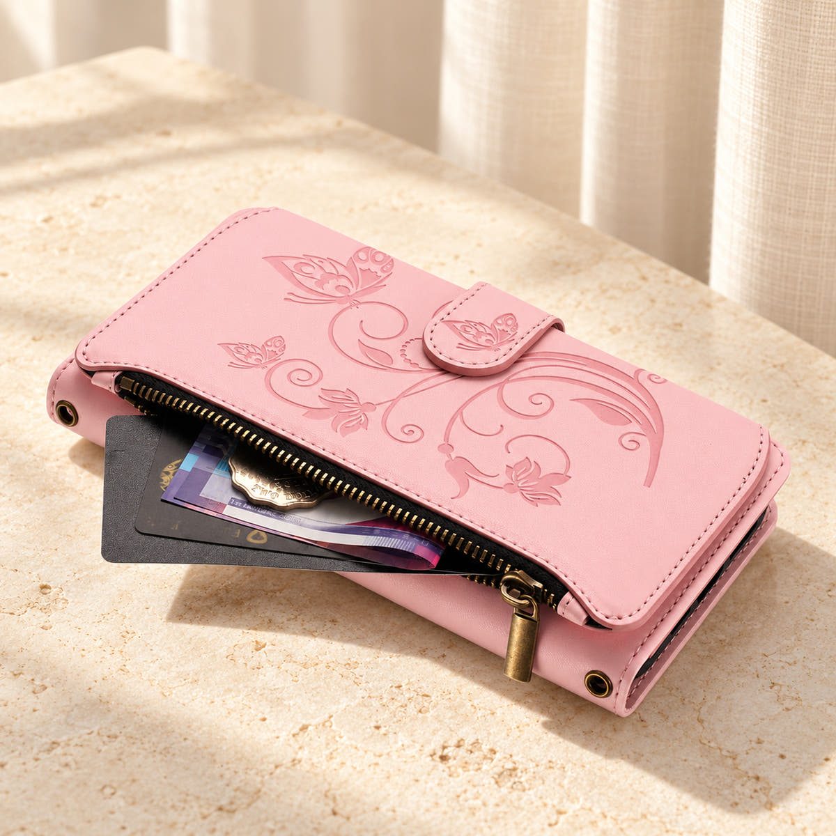 Velora Zip wallet case in Pink on cream limestone, showing the embossed front and open side zip pocket with cards and cash.