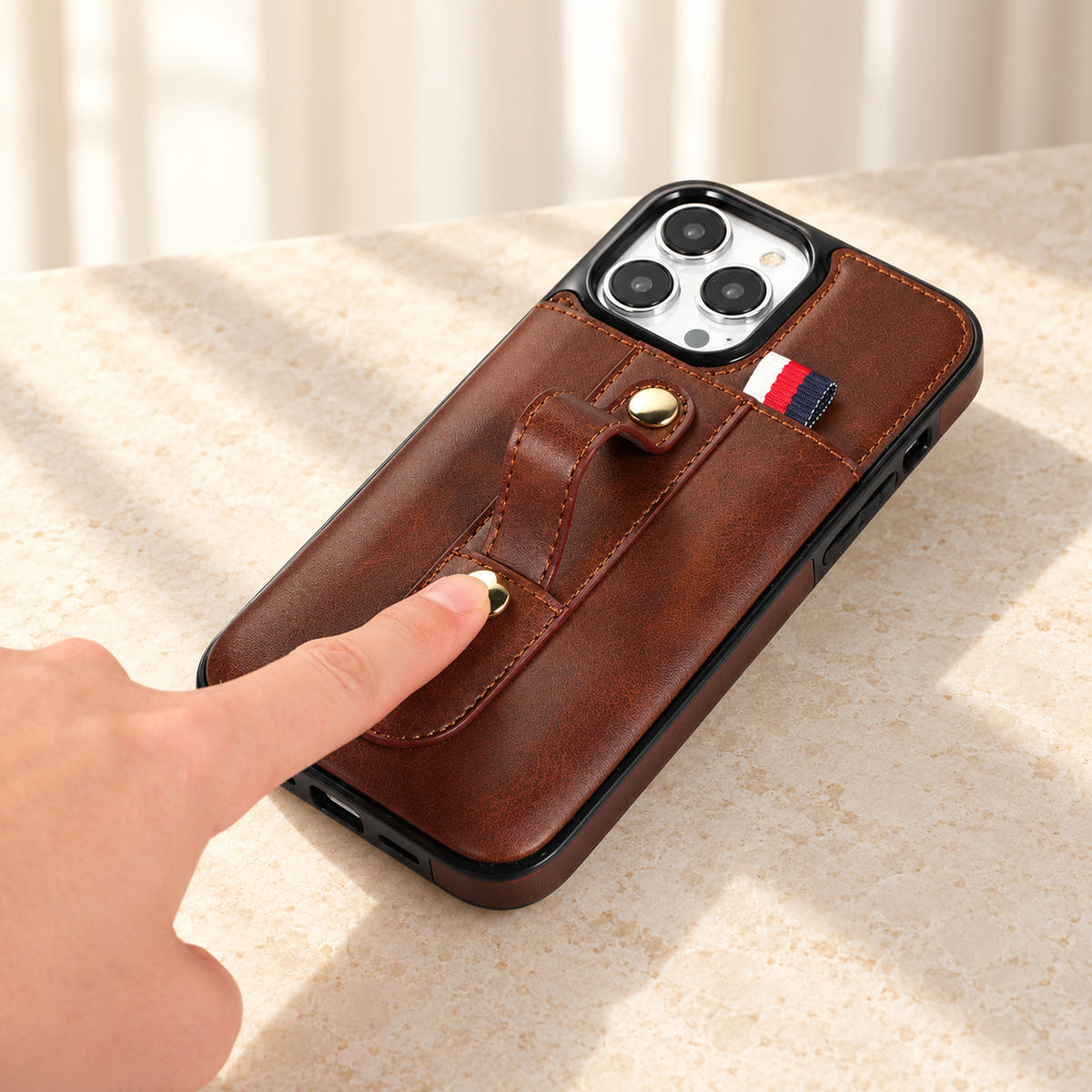Brown iPhone wallet case with card pocket and adjustable hand strap, adjustment
