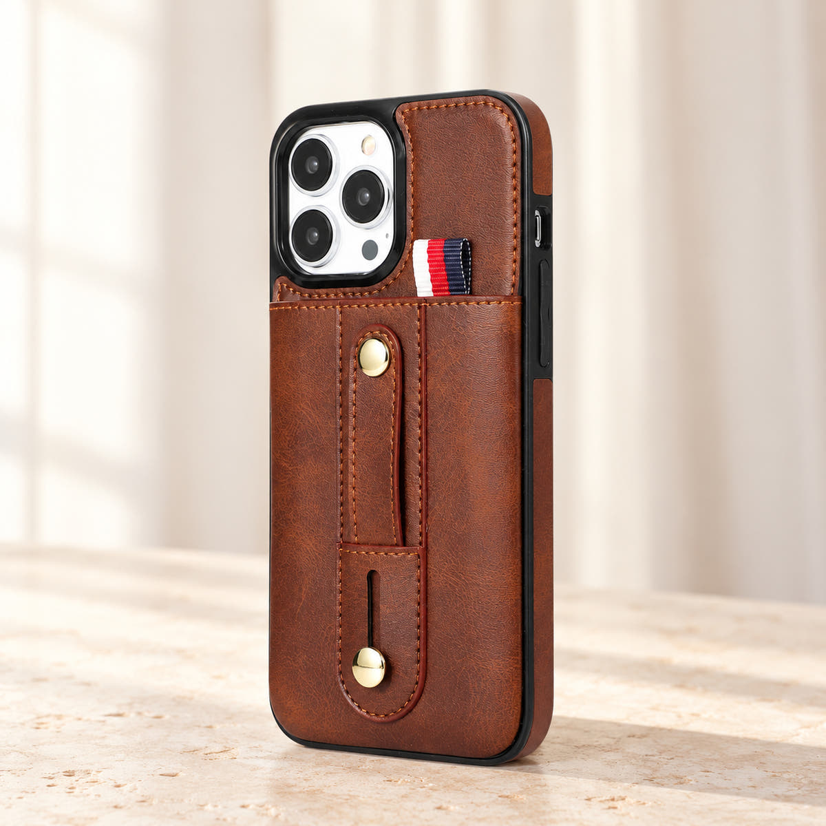 Brown iPhone wallet case with card pocket and adjustable hand strap, angle