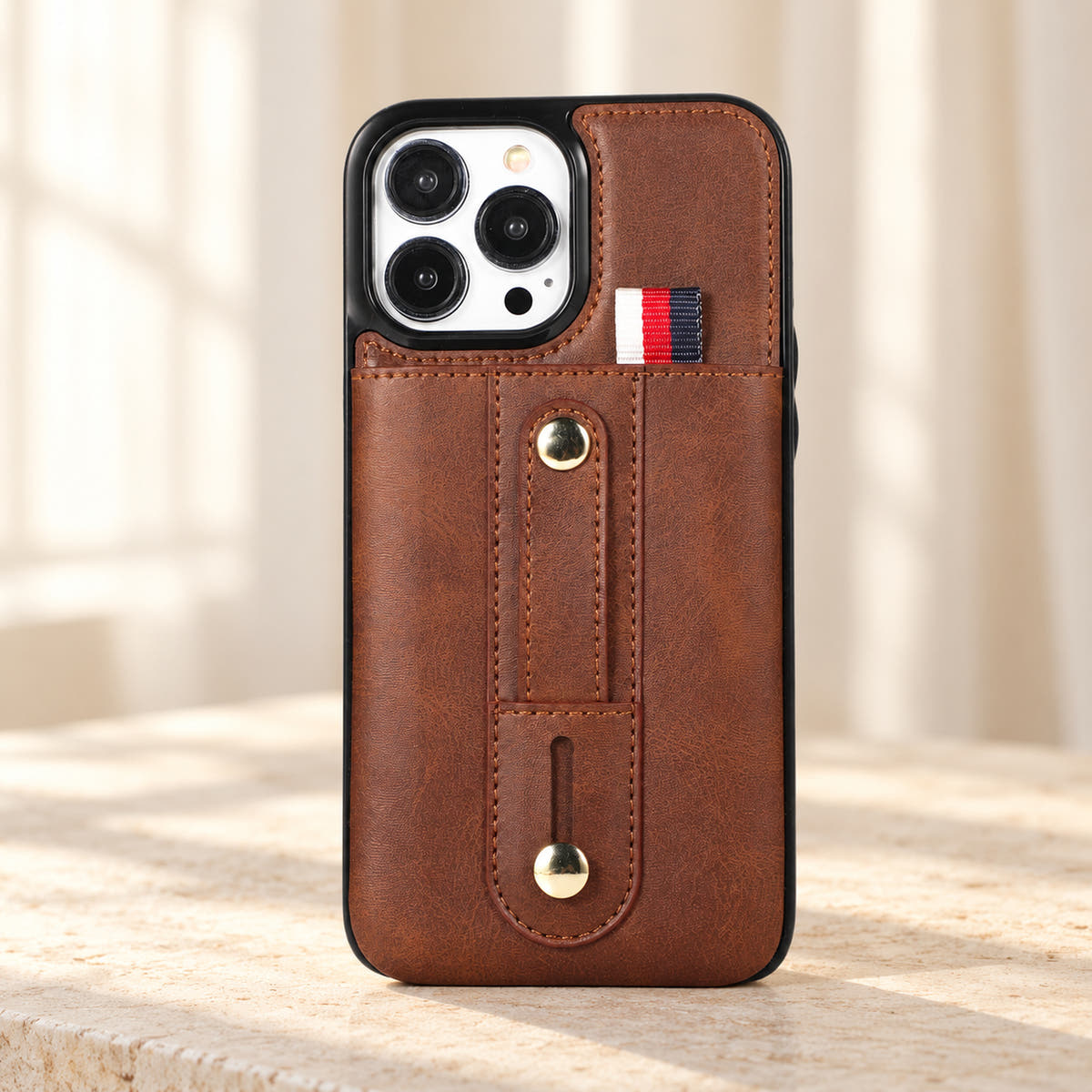 Brown iPhone wallet case with card pocket and adjustable hand strap, hero