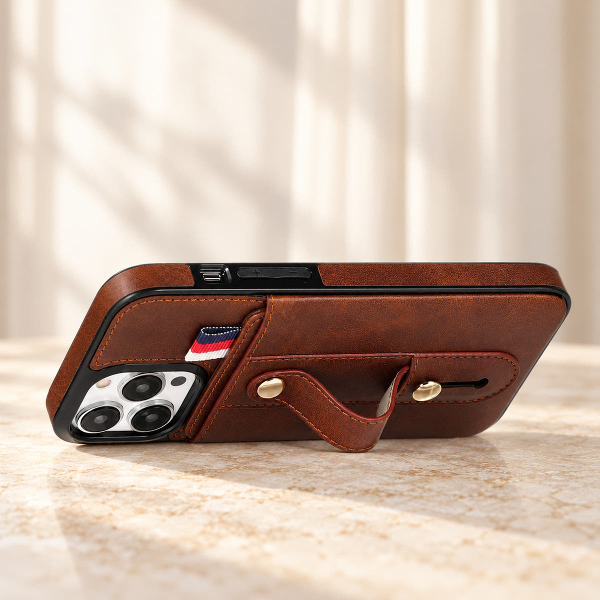 Brown iPhone wallet case with card pocket and adjustable hand strap, stand