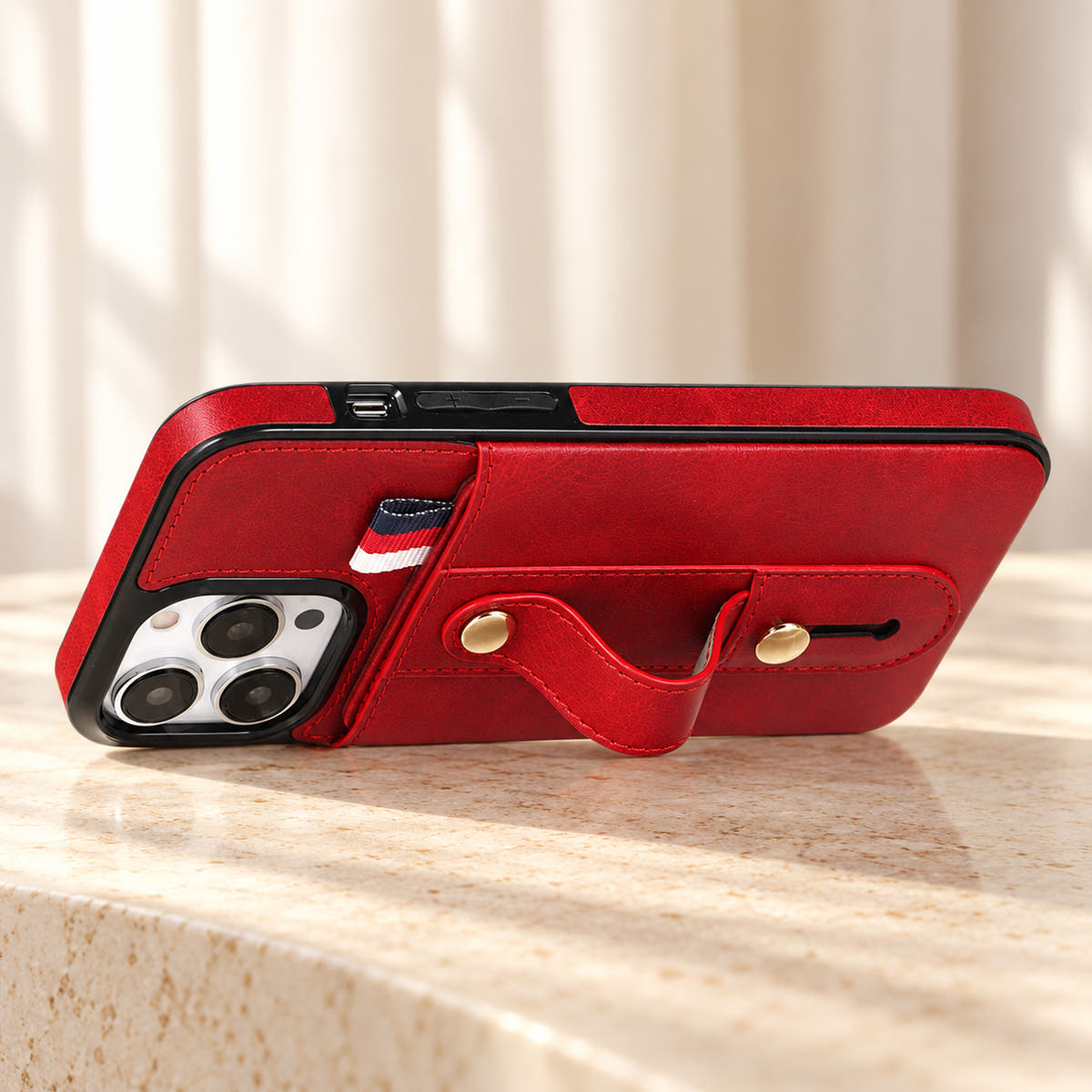 Red iPhone wallet case with card pocket and adjustable hand strap, stand