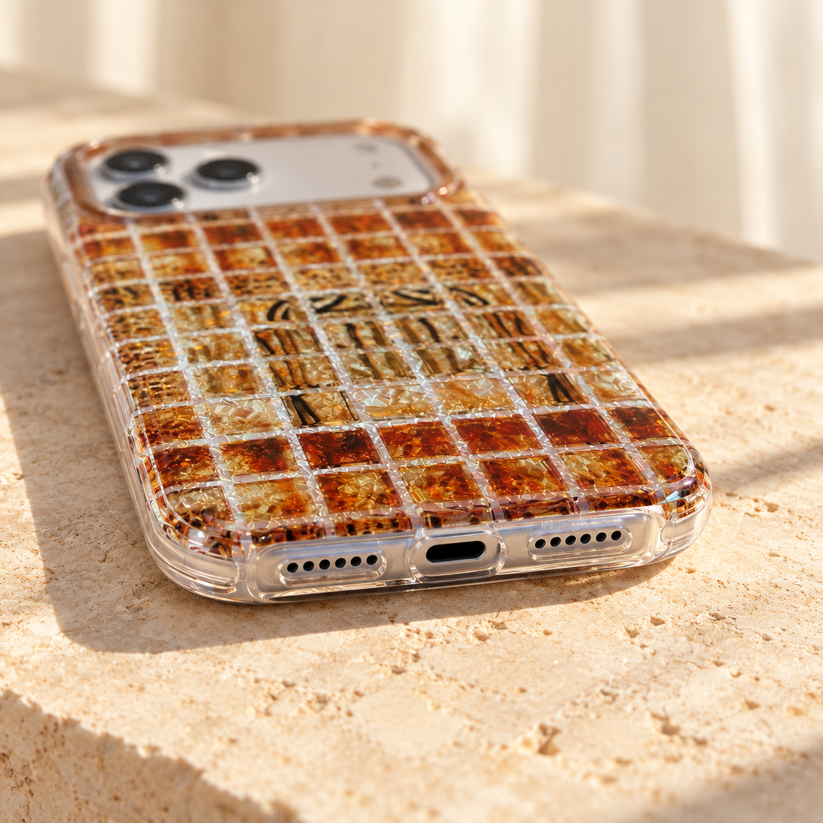 Bottom opening and clear-edge detail of the Plaid Amber Shimmer iPhone case.