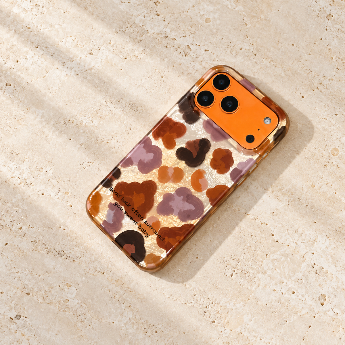 Overhead view of the Autumn Mix floral case on pale limestone, showing its full warm-toned print.