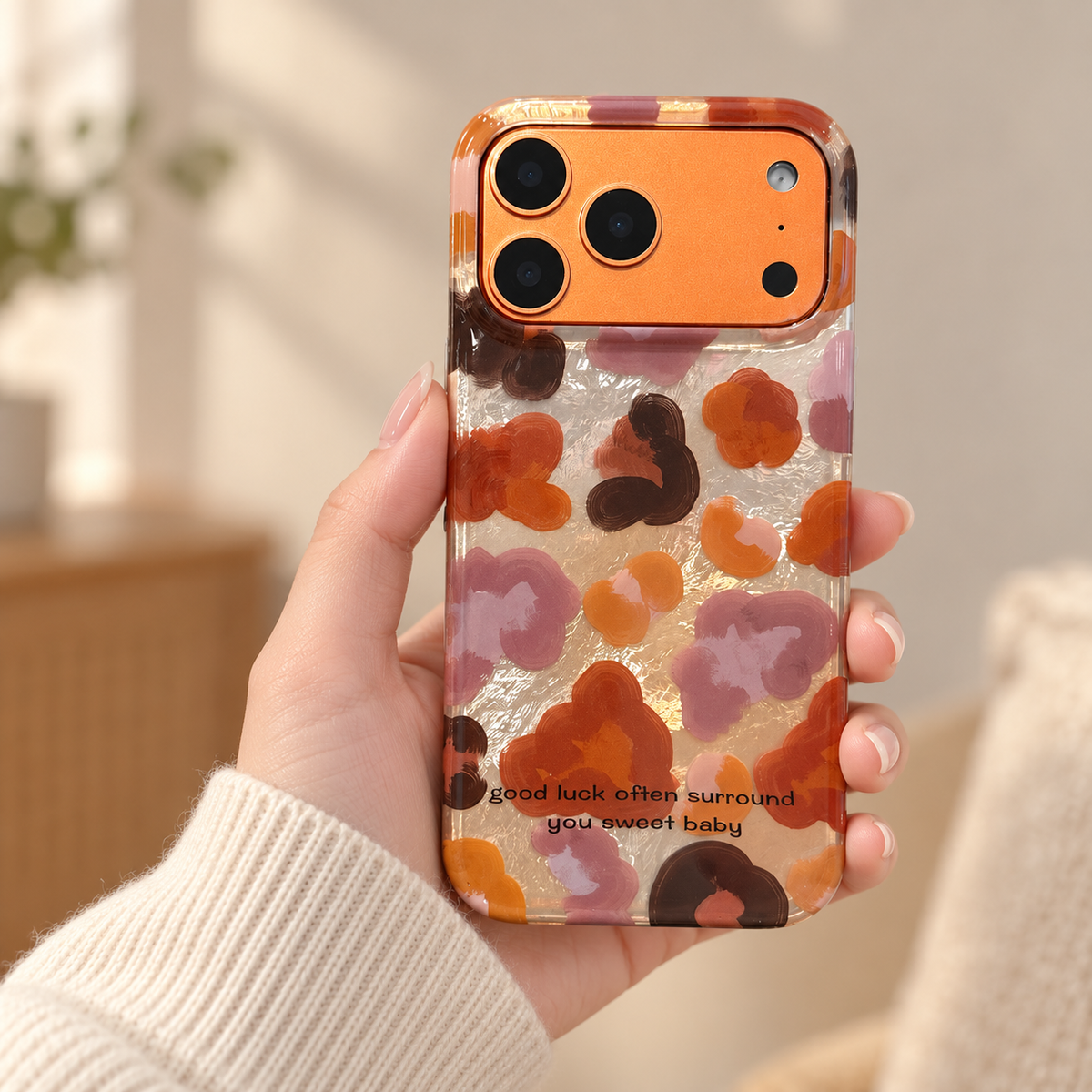 Autumn Mix floral iPhone case held in one hand against a soft cream background.
