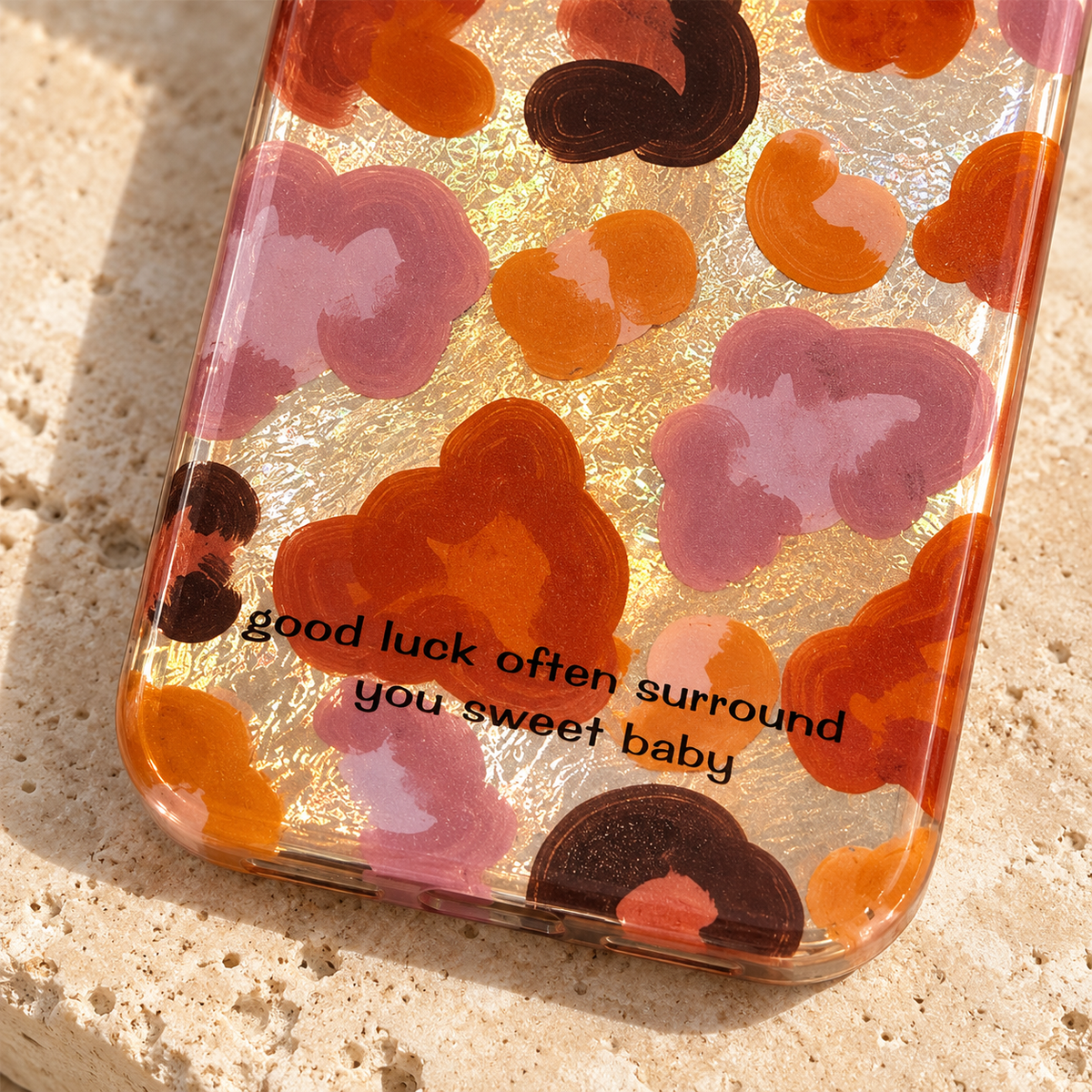 Close-up of the Autumn Mix case's printed good-luck message, warm floral artwork and rounded lower edge.