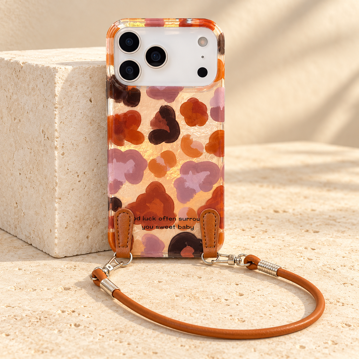 Autumn Mix case standing against an ivory block with the pictured brown wrist loop resting on the tabletop.