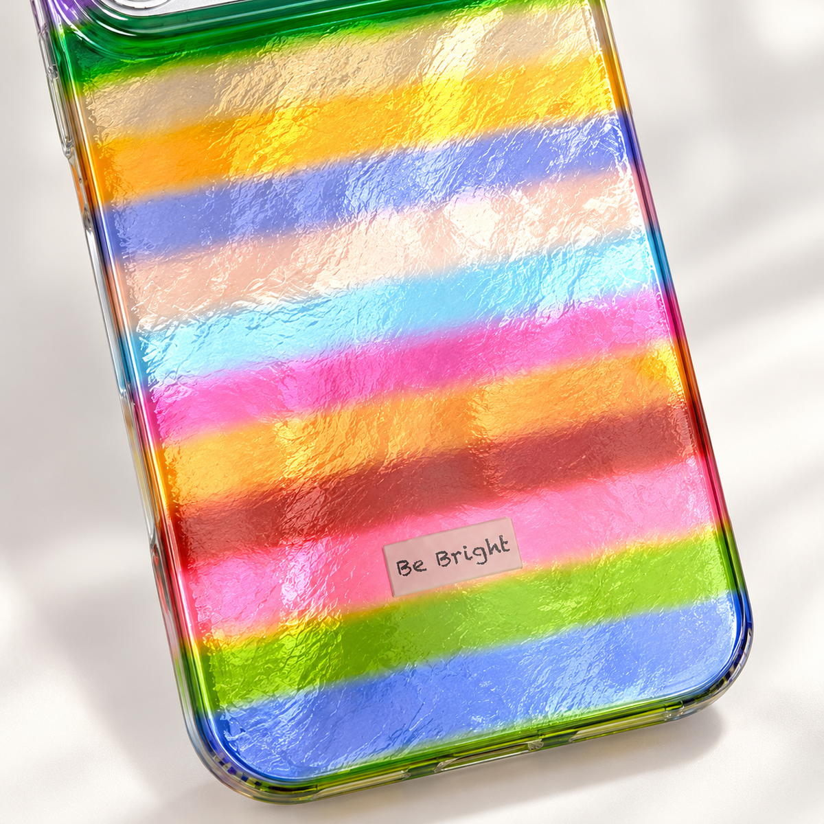 Be Bright rainbow stripe iPhone case — Be Bright label close-up.