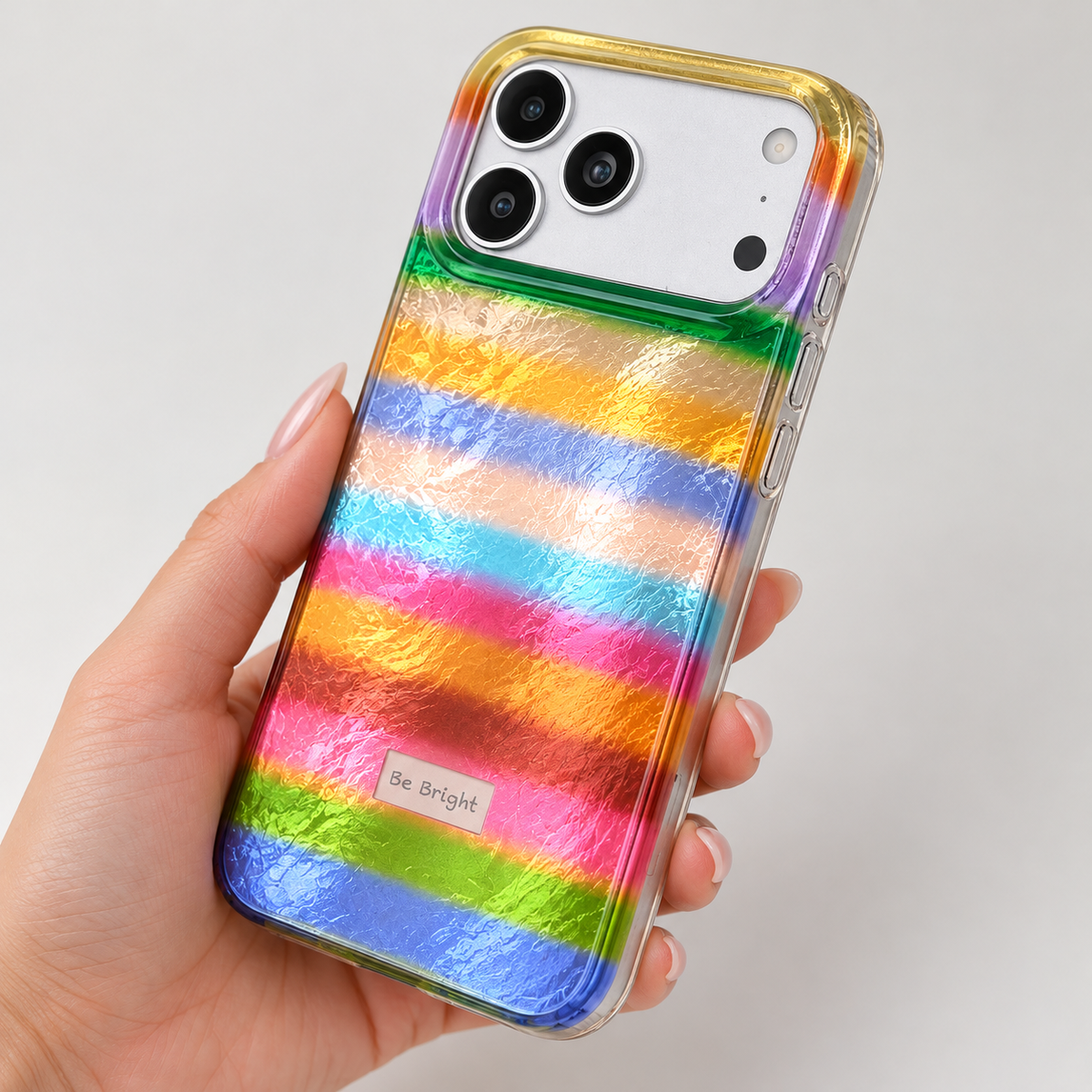 Be Bright rainbow stripe iPhone case — clear side edge and controls detail.