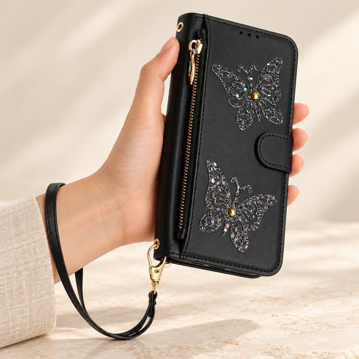 Black Butterfly iPhone wallet case — front view with wrist strap