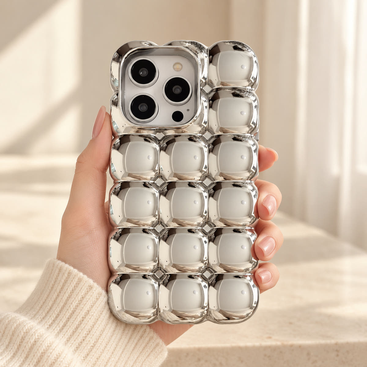 Silver Chrome Bubble Bear iPhone case — handheld relaxed view