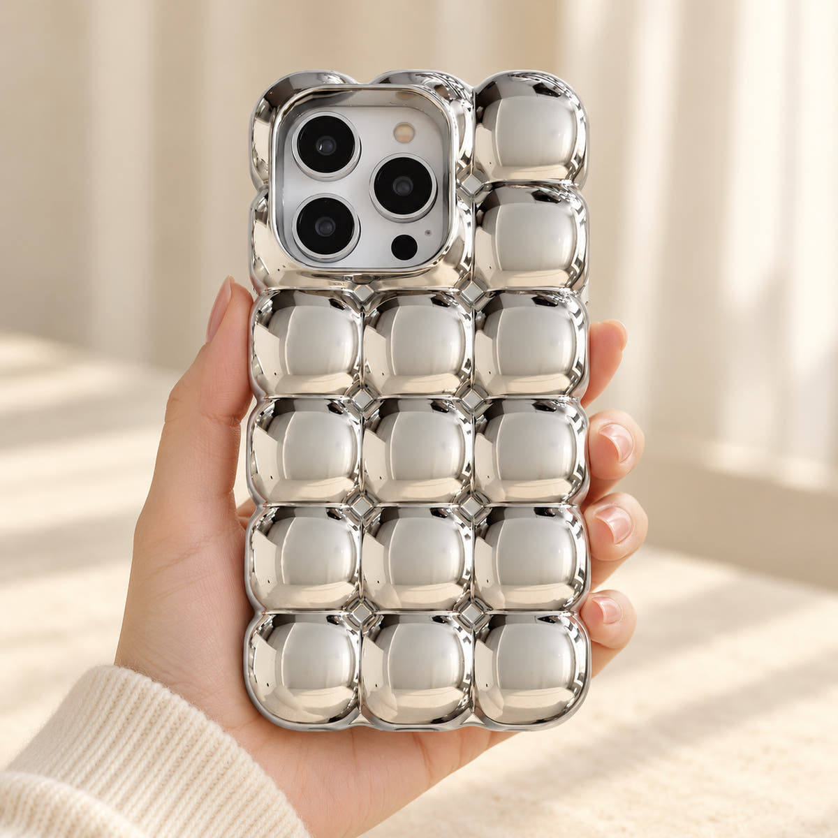 Silver Chrome Bubble Bear iPhone case — handheld scale view