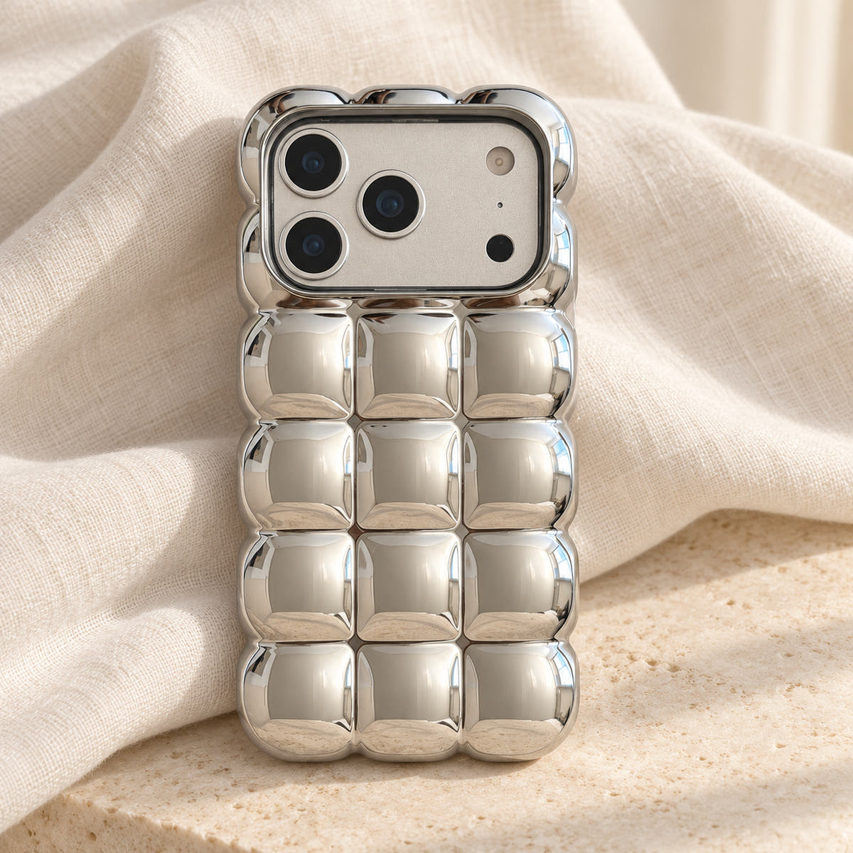 Silver Chrome Bubble Bear iPhone case — linen flatlay view