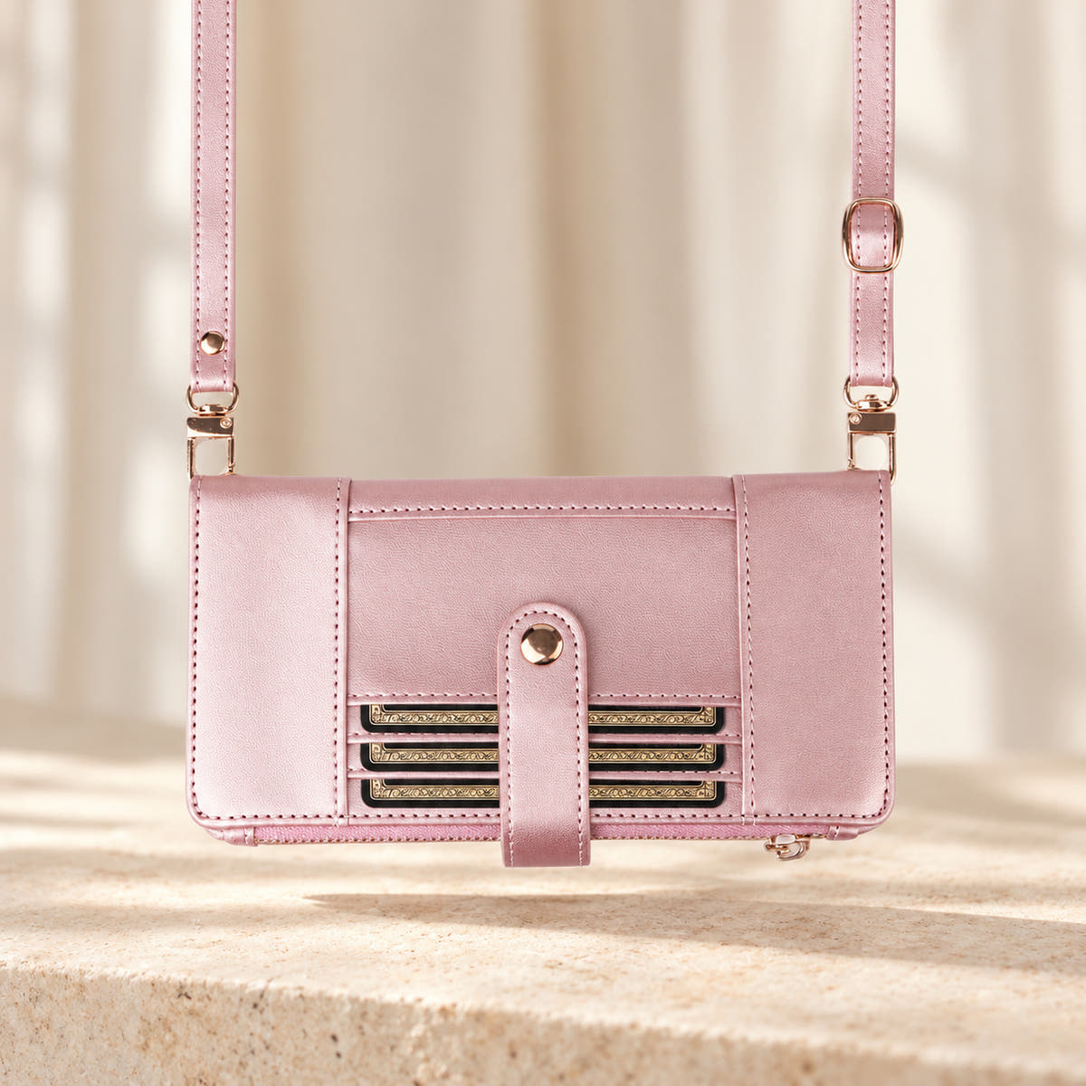 Elaris Crossbody iPhone wallet case in Pink, landscape view with adjustable crossbody strap.