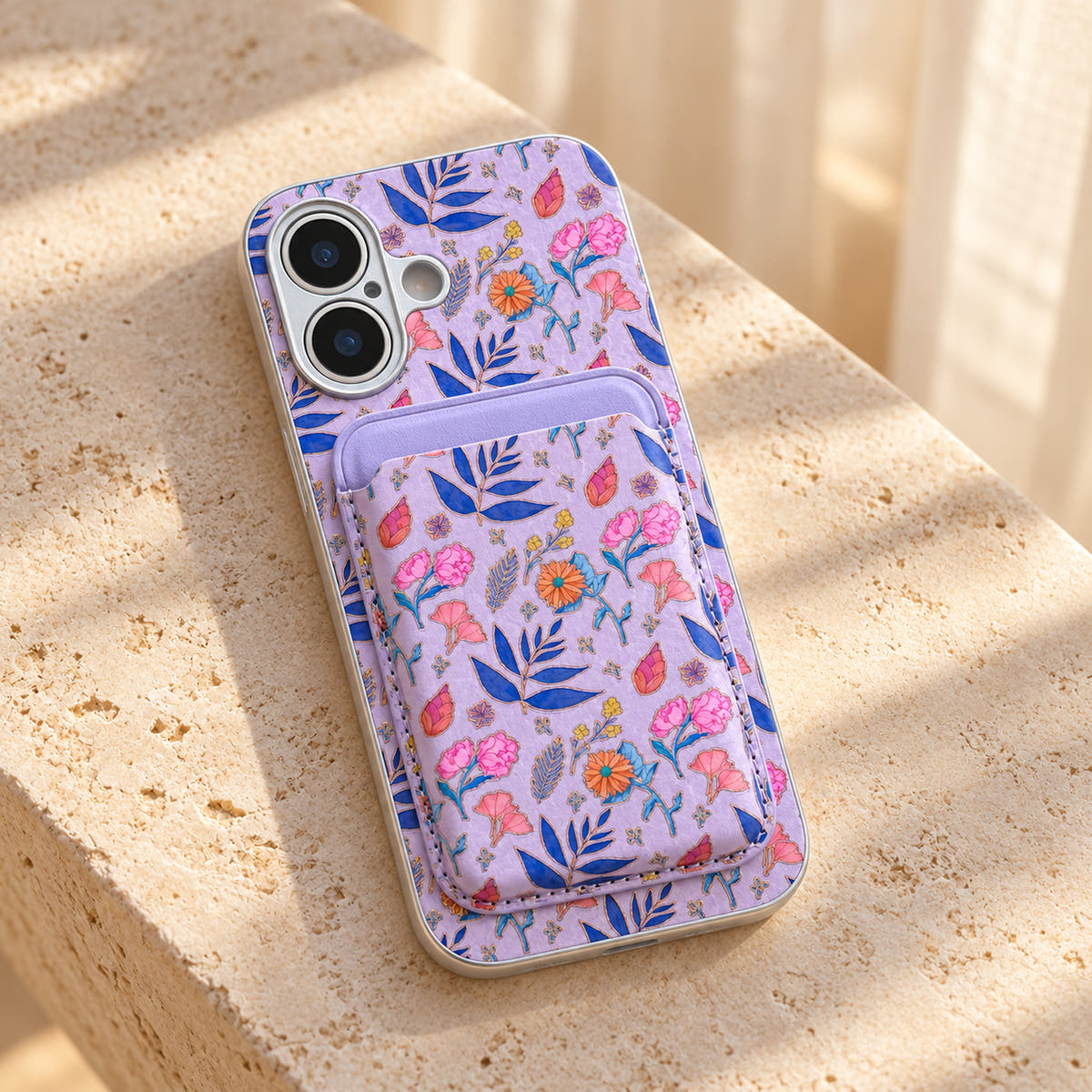 Lavender Elysia Floral phone case and attached card wallet resting on a warm cream stone tabletop.