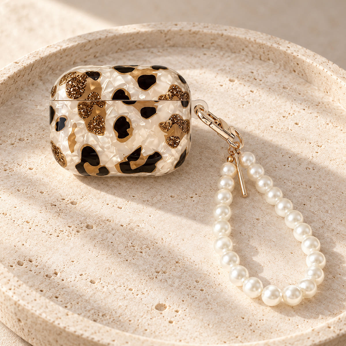 Gilded Leopard Heart AirPods case Design #1 — pedestal showing its pearl-style wrist loop