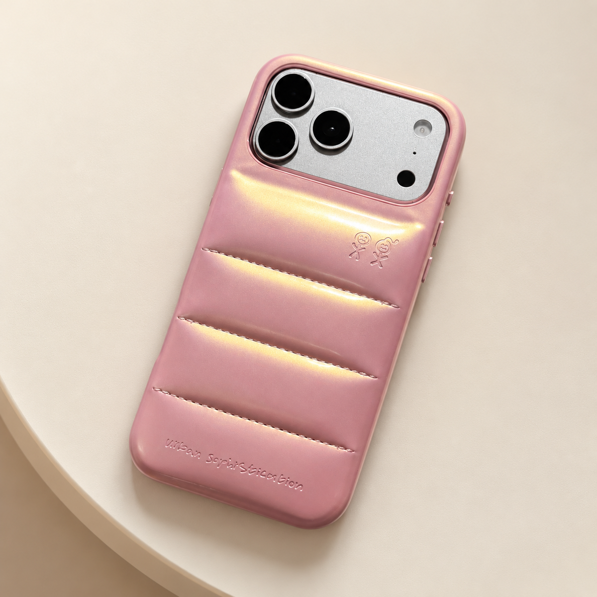 Overhead-style view of the Iridescent Pink puffer case on a clean cream tabletop.