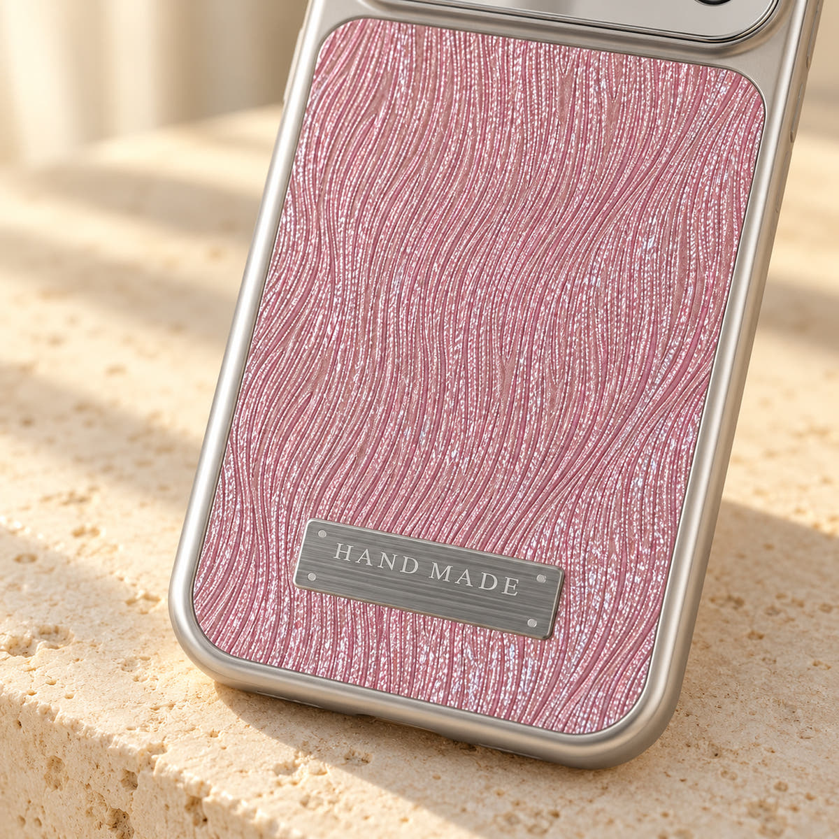 Luna Belle textured shimmer iPhone case in Pink, close-up of the wave texture and silver-tone plaque.