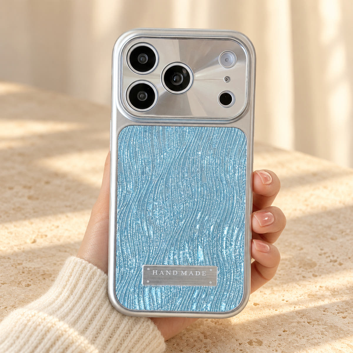 Luna Belle textured shimmer iPhone case in Sky Blue, held upright.