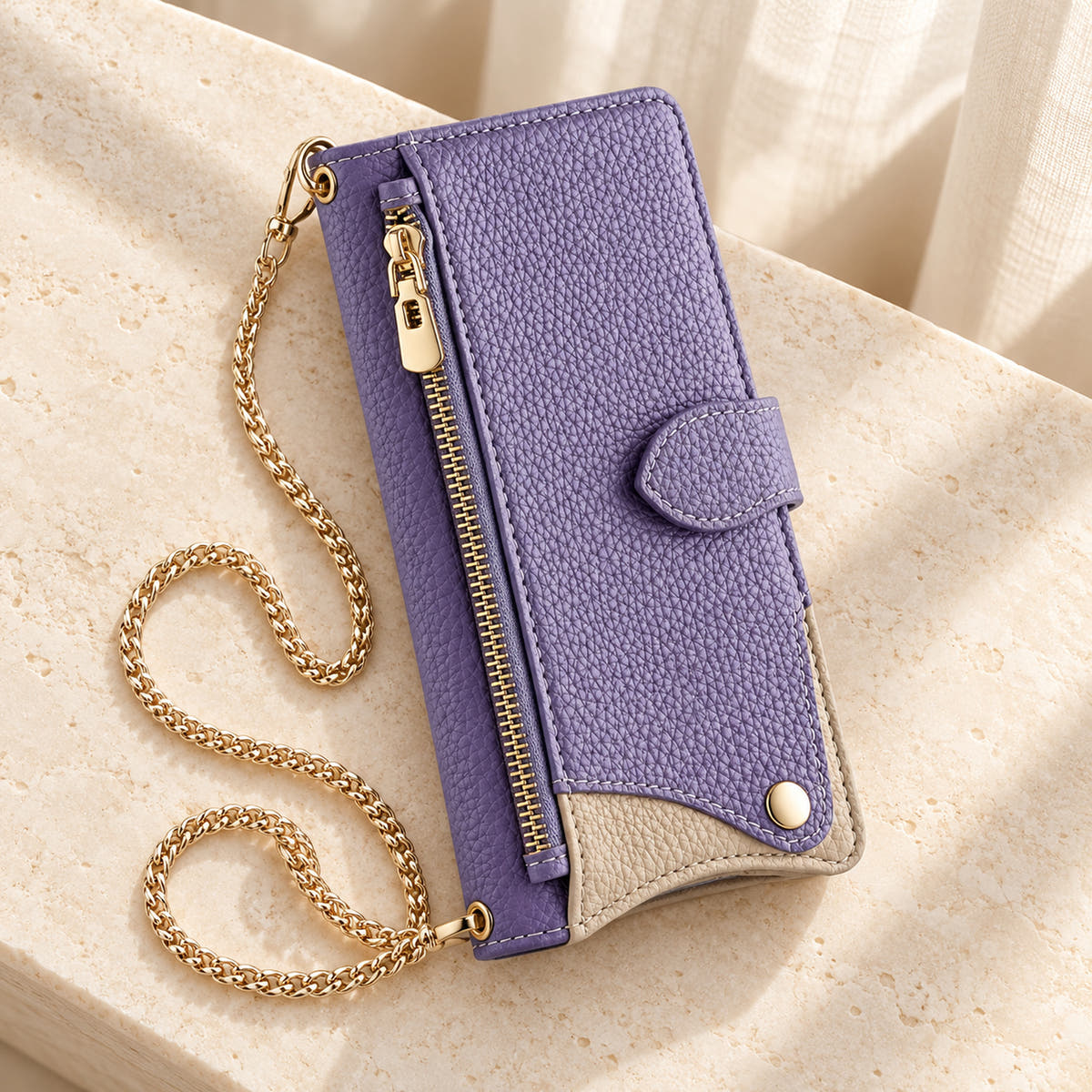 Luxe Colourblock iPhone wallet case in Lavender with gold-tone chain arranged on cream limestone
