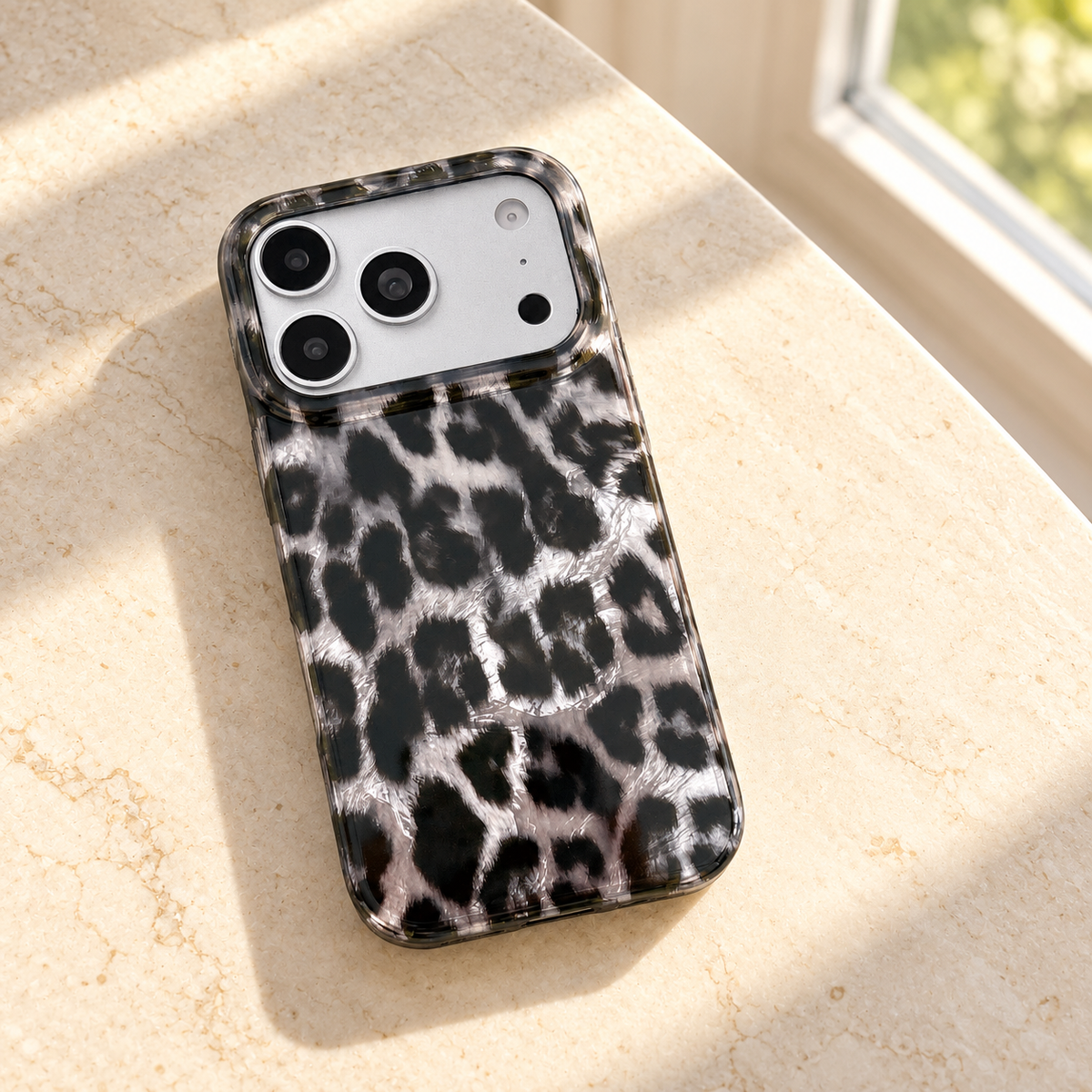 Leopard print case resting diagonally on a cream tabletop in window light.