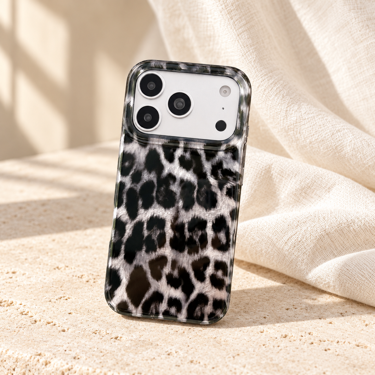 Upright leopard print case against a softly draped ivory background.