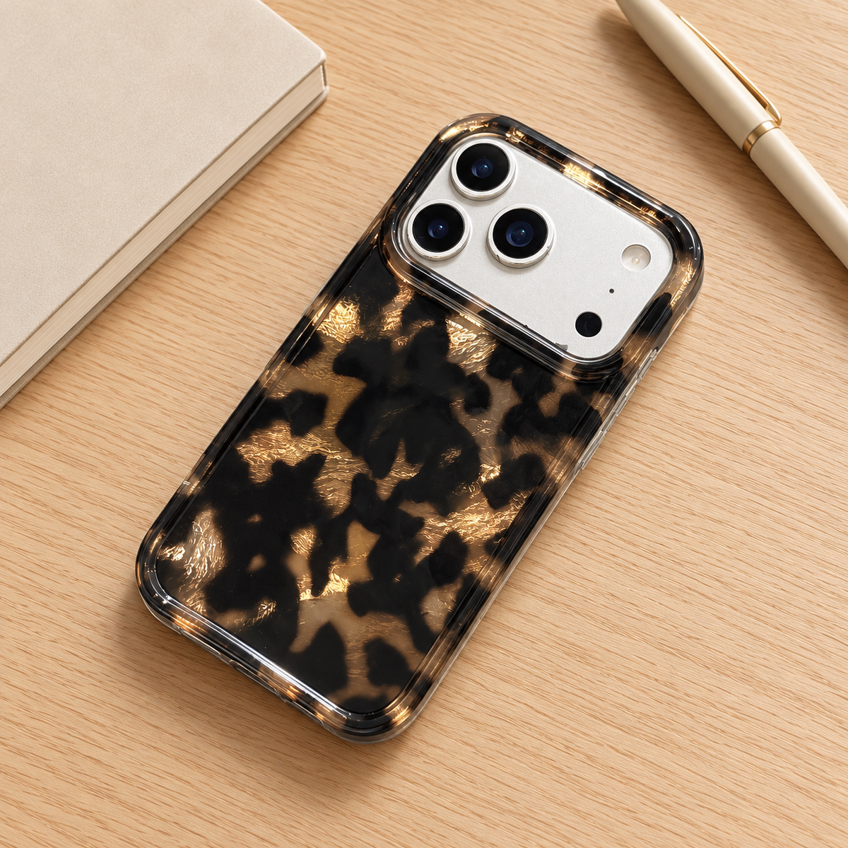 Dark Tortoiseshell iPhone case with black and warm brown mottled pattern — rear view on a desk.