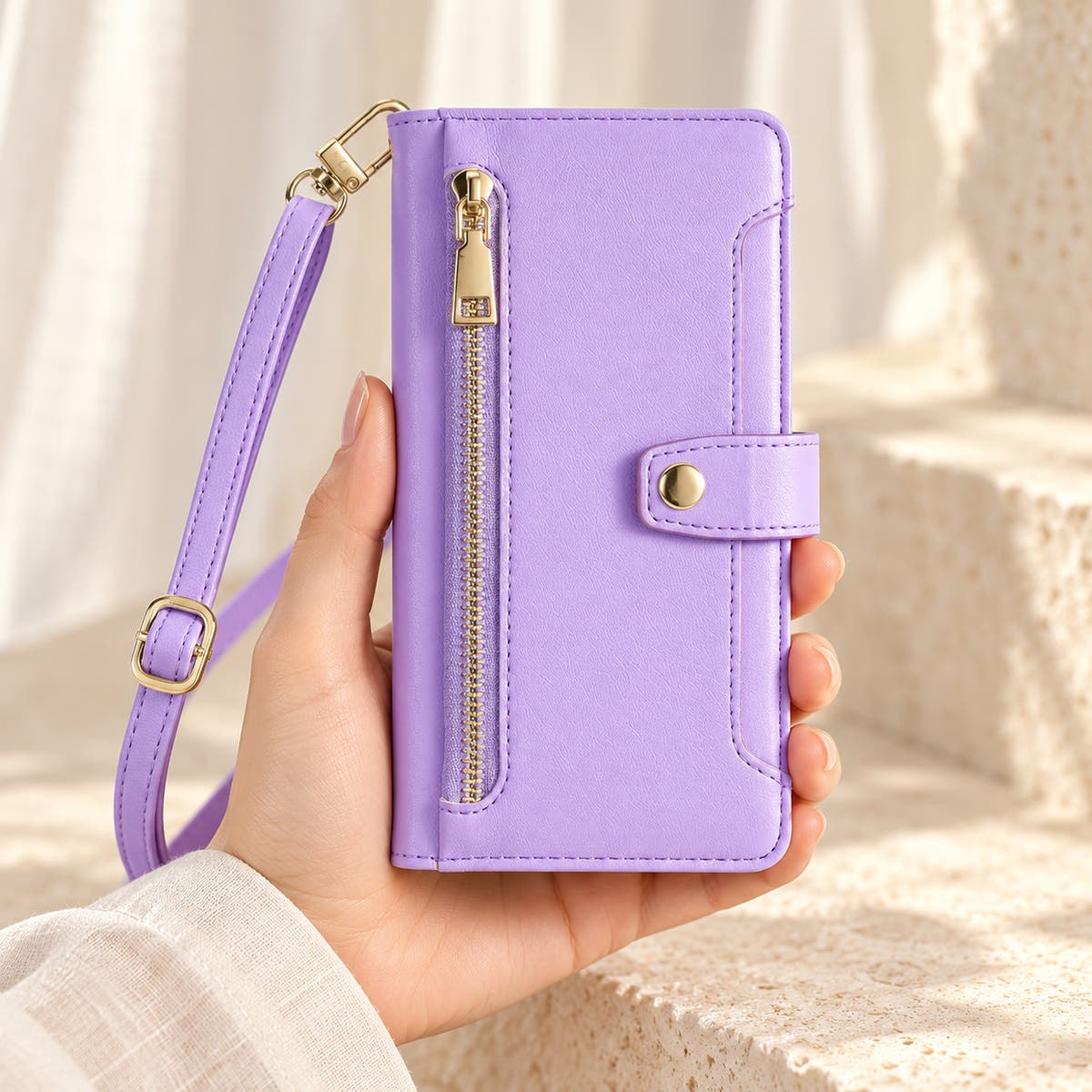 Minimal crossbody iPhone wallet case in Lavender — front held in hand showing gold-tone zip and closure tab