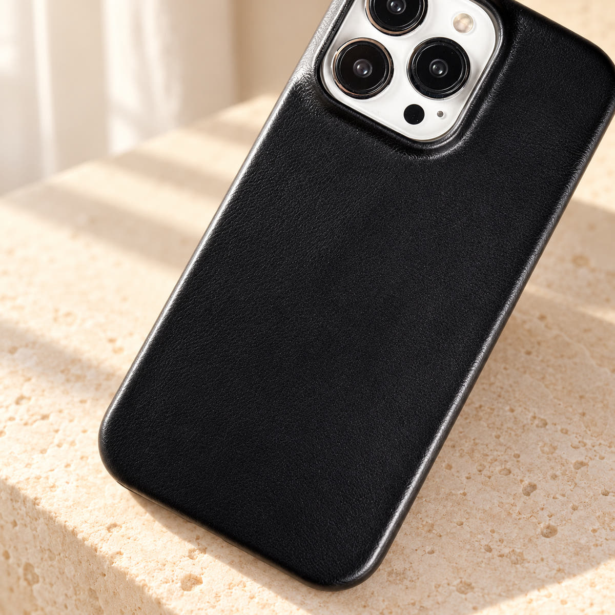 Minimal leather-look iPhone case in Black, close-up of the fine-grained back and rounded corners.