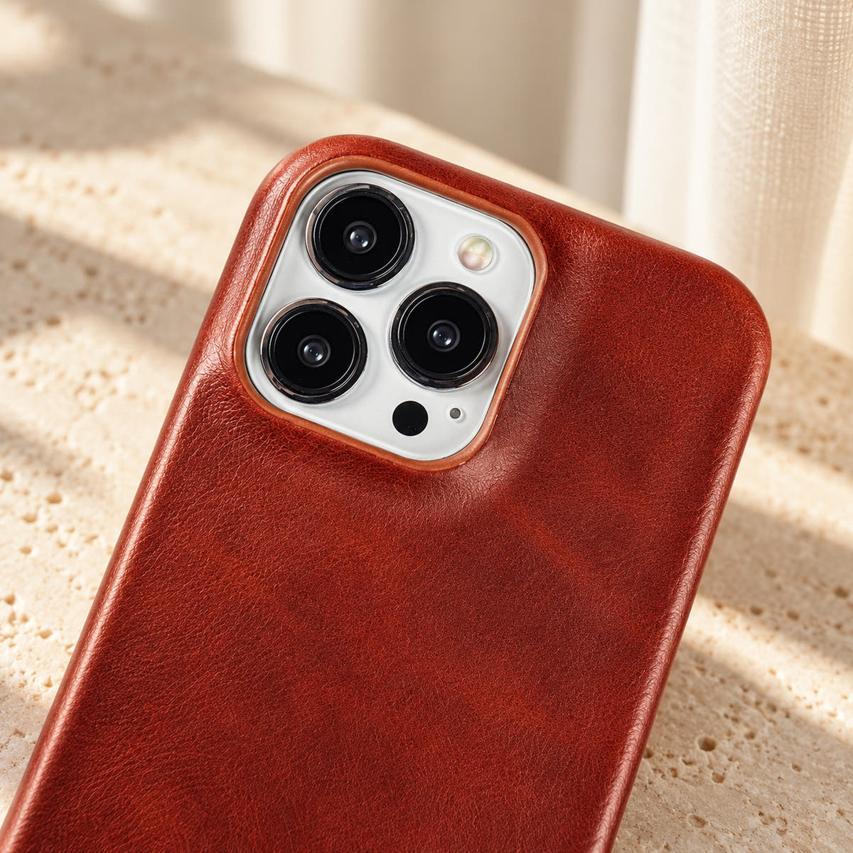 Minimal leather-look iPhone case in Brown, close-up of the matching camera border.