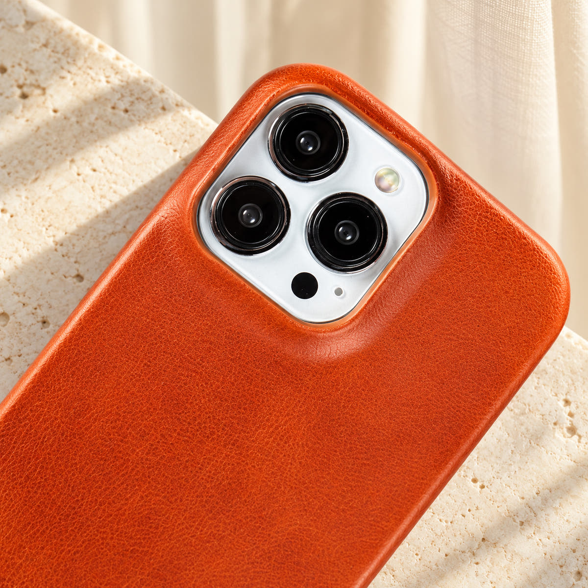 Minimal leather-look iPhone case in Light Brown, close-up of the matching camera border.
