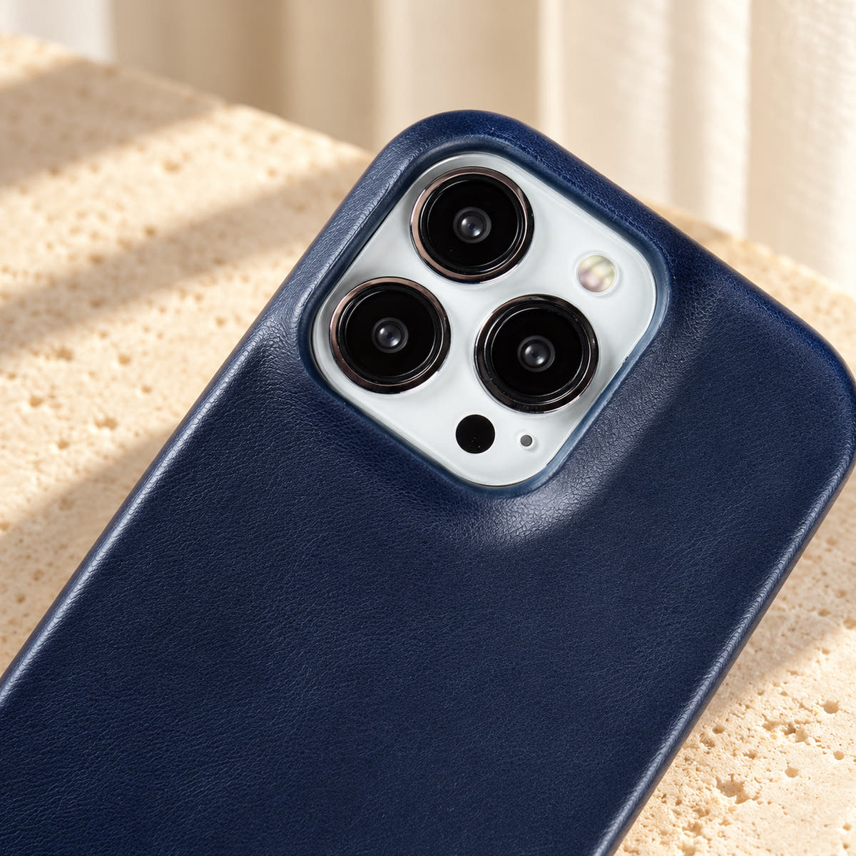 Minimal leather-look iPhone case in Midnight Blue, close-up of the matching camera border.