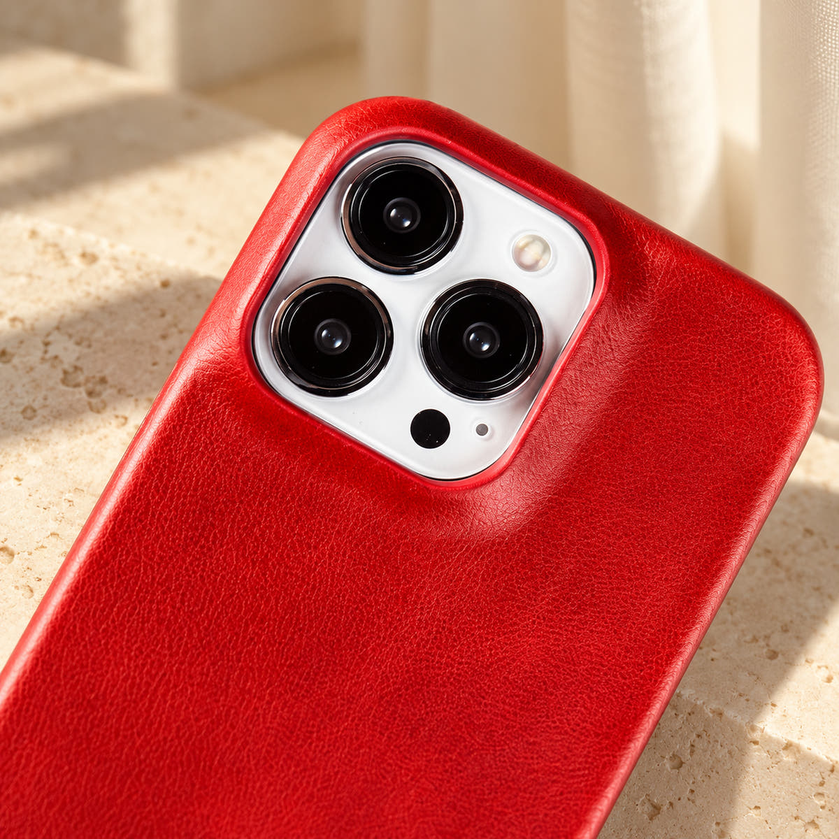 Minimal leather-look iPhone case in Red, close-up of the matching camera border.
